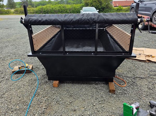 Steel mesh cab guard with roll-out tarp on the front of the insert